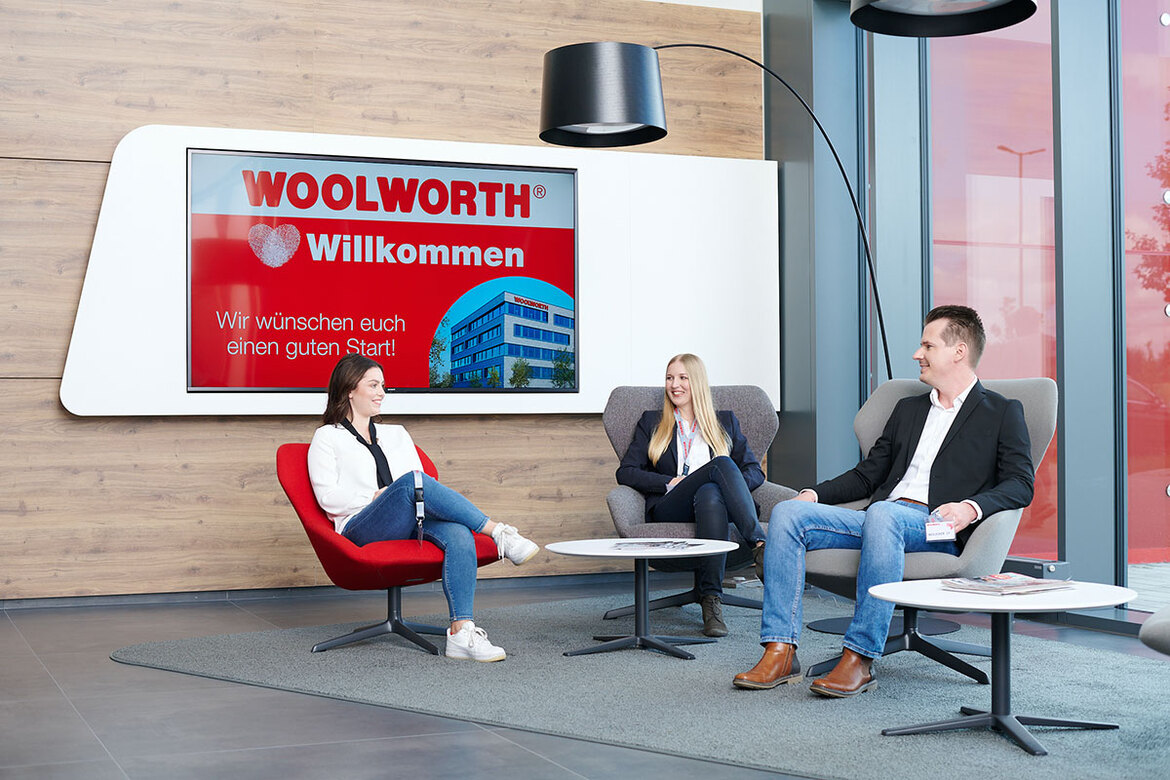 Personen sitzen zusammen auf Sesseln in Woolworth Zentrale