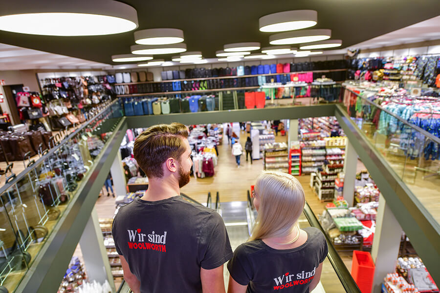 Mitarbeiter fahren Rolltreppe in Woolworth Kaufhaus hinab